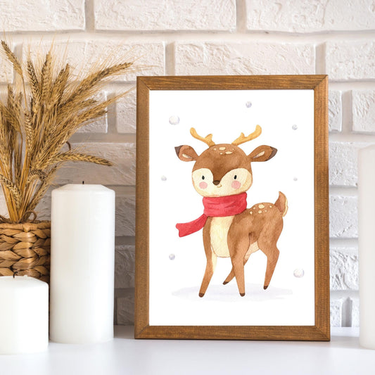 Weihnachtsposter Rentier mit Schal, handgemaltes Kinderbild, zeigt ein süßes Reh im Schnee, gerahmt neben Weihnachtsdekoration neben Kerzen, ideal als Deko oder Geschenk.