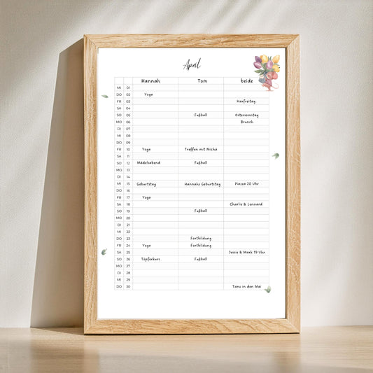 Paarkalender 2026 zum Ausdrucken A3 & A4: Ein minimalistischer Kalender mit handgemalten Illustrationen und drei Spalten für persönliche und gemeinsame Termine, gerahmt auf einem Tisch.