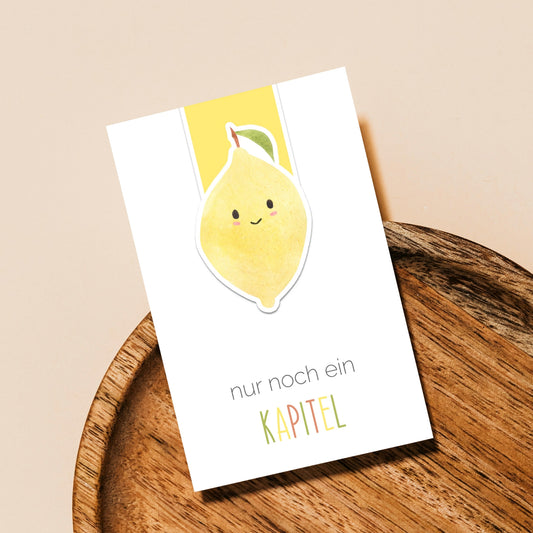 Magnetisches Lesezeichen Zitrone: Handgemaltes, lächelndes Zitronenmotiv auf matt versiegeltem Papier, ideal für Buchliebhaber. Enthält Magnete für schonendes Seitenhalten.