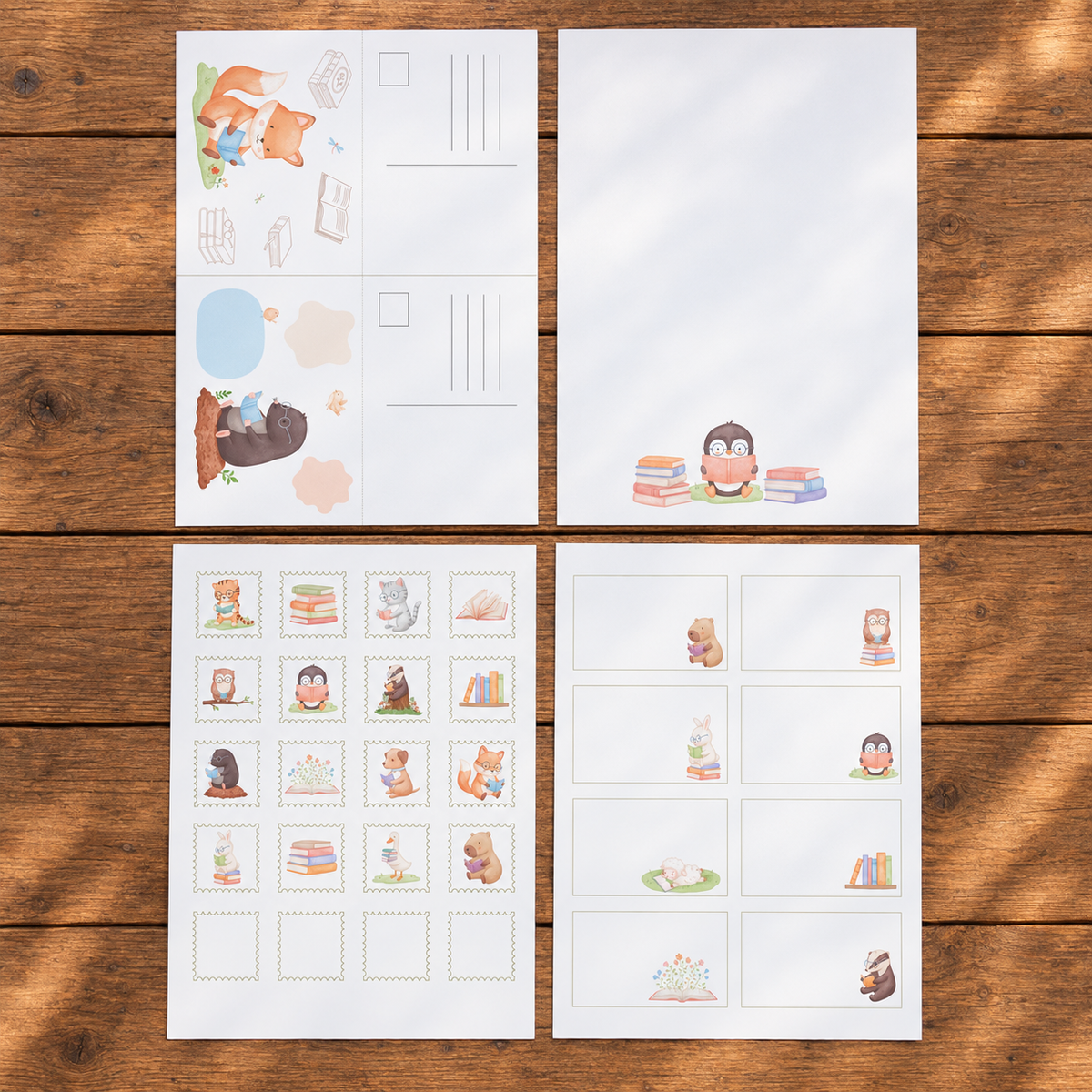 Vier A4-Seiten eines Kinder-Postsets auf einem Holztisch mit Postkarten, Briefpapier, Briefmarken, Etiketten und Stickern.