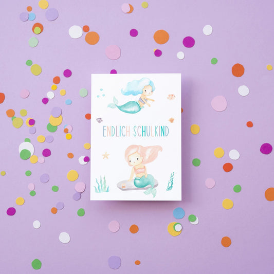 Karte Endlich Schulkind Meerjungfrau A6 mit zwei pastellfarbenen Meerjungfrauen und Meeresmotiven, ideal für Einschulungsglückwünsche, gedruckt auf hochwertigem, beschreibbarem Naturpapier.