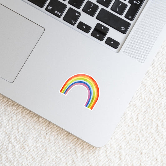 Laptop-Ecke mit dem Sticker Regenbogen auf der Handballenauflage, der positive Energie ausstrahlt; ideal für Notizbücher, Laptops oder Handys.
