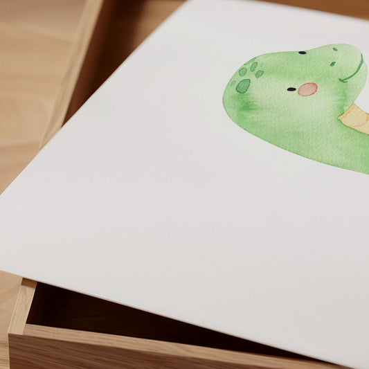 Geburtsposter Dino personalisiert zeigt ein freundliches Dinosaurier-Skizze auf weißem Aquarellpapier, liegend auf einer Holzbox, ideal für Kinderzimmerdeko.