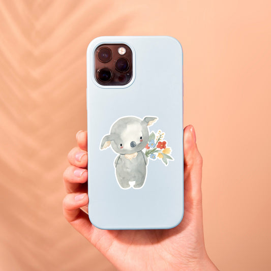 Hand hält Telefonhülle mit Cartoon-Koala, der Blumen hält. Sticker Koala & Blumen verleiht Geräten einen individuellen Charme, spritzfest und langlebig.