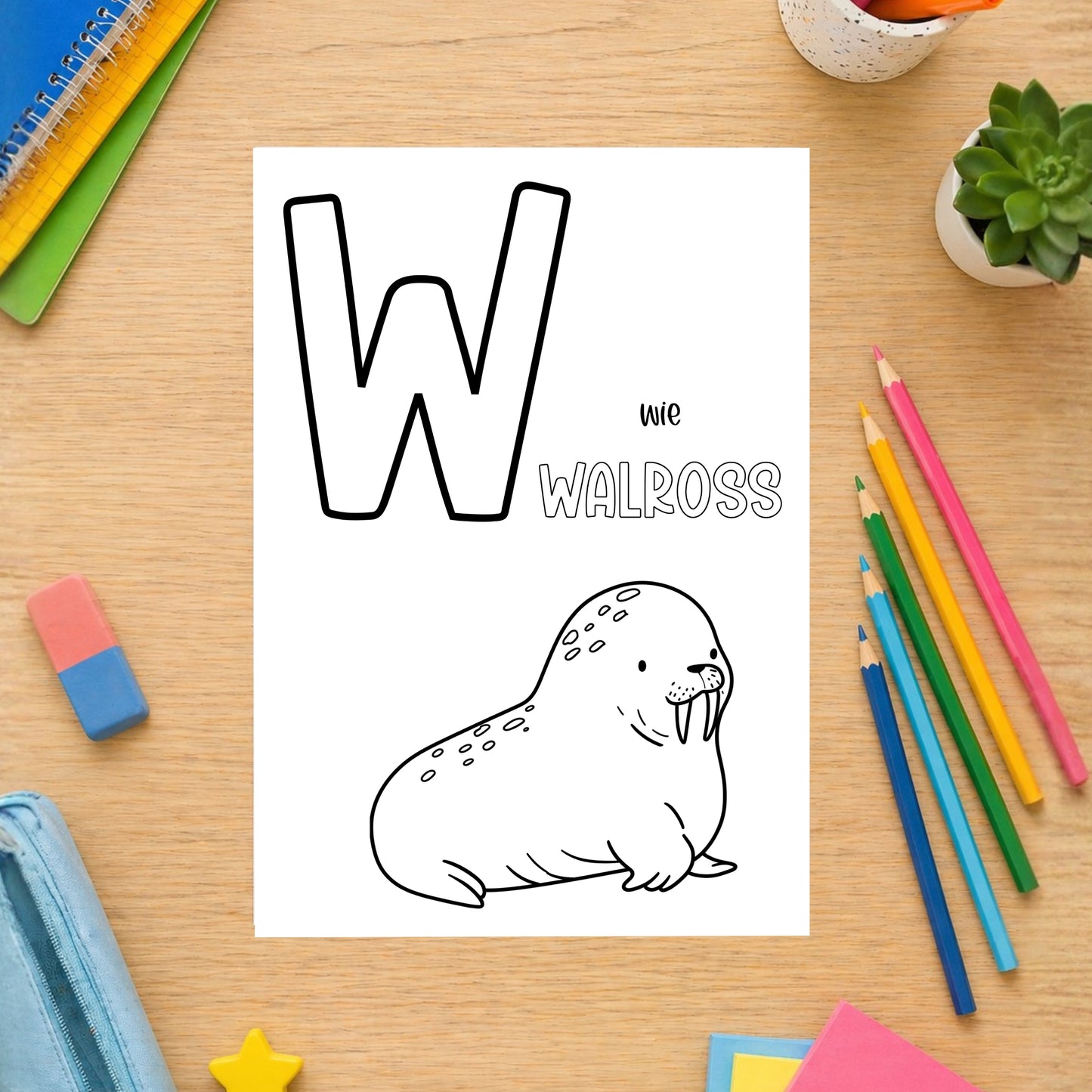 Tierisches Alphabet – Ausmalbilder zum Ausdrucken: Malstation mit einem W-Ausmalblatt, umgeben von Schulmaterialien wie Notizbüchern, Buntstiften und einem Radiergummi.