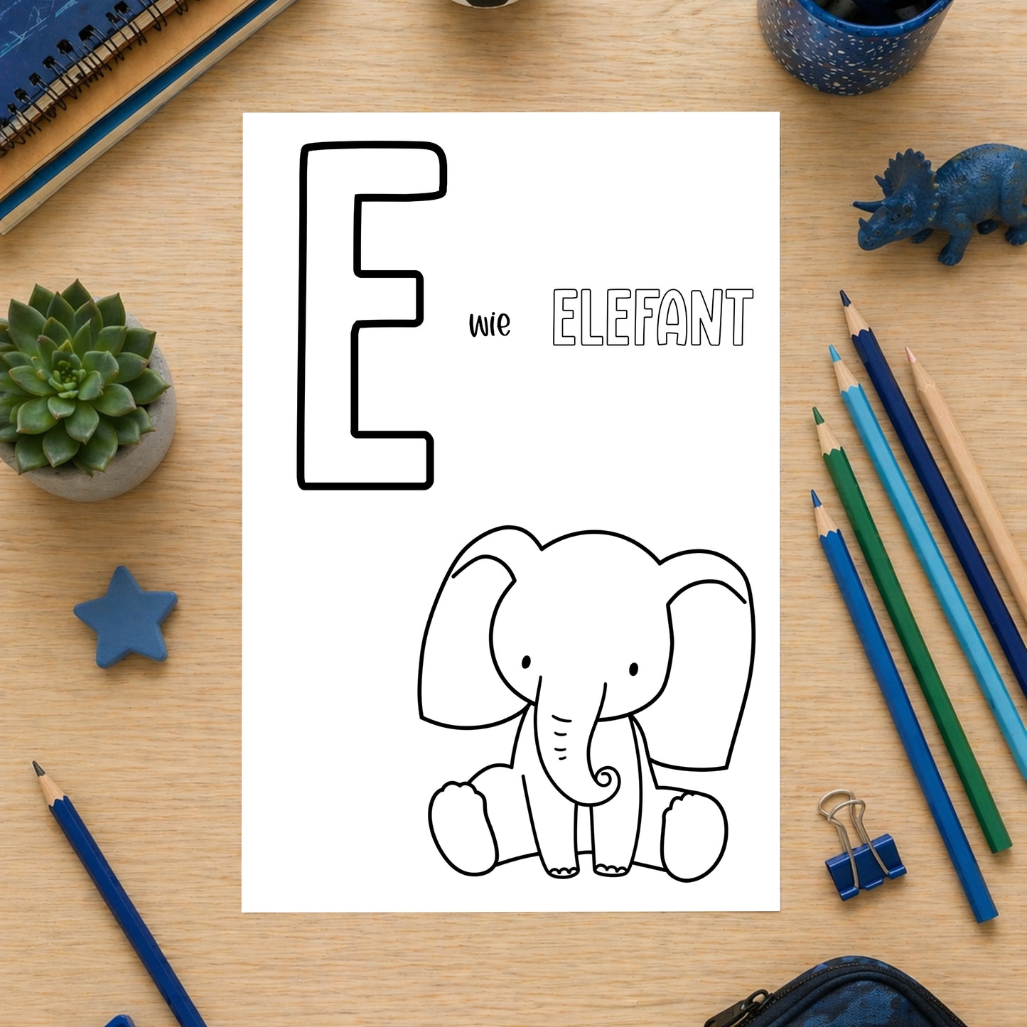 Tierisches Alphabet – Ausmalbilder zum Ausdrucken: Arbeitsblatt „E wie Elefant“ zum Ausmalen, umgeben von Schulmaterialien auf Holztisch. Ideal für spielerisches Lernen.