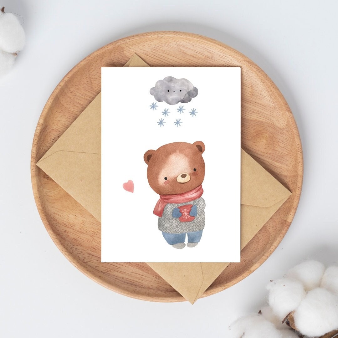 Postkarte Karte Bär im Schnee A6 mit Teddybär-Aquarell, der eine im Schnee. Auf einem Holzbrett mit Umschlag platziert.