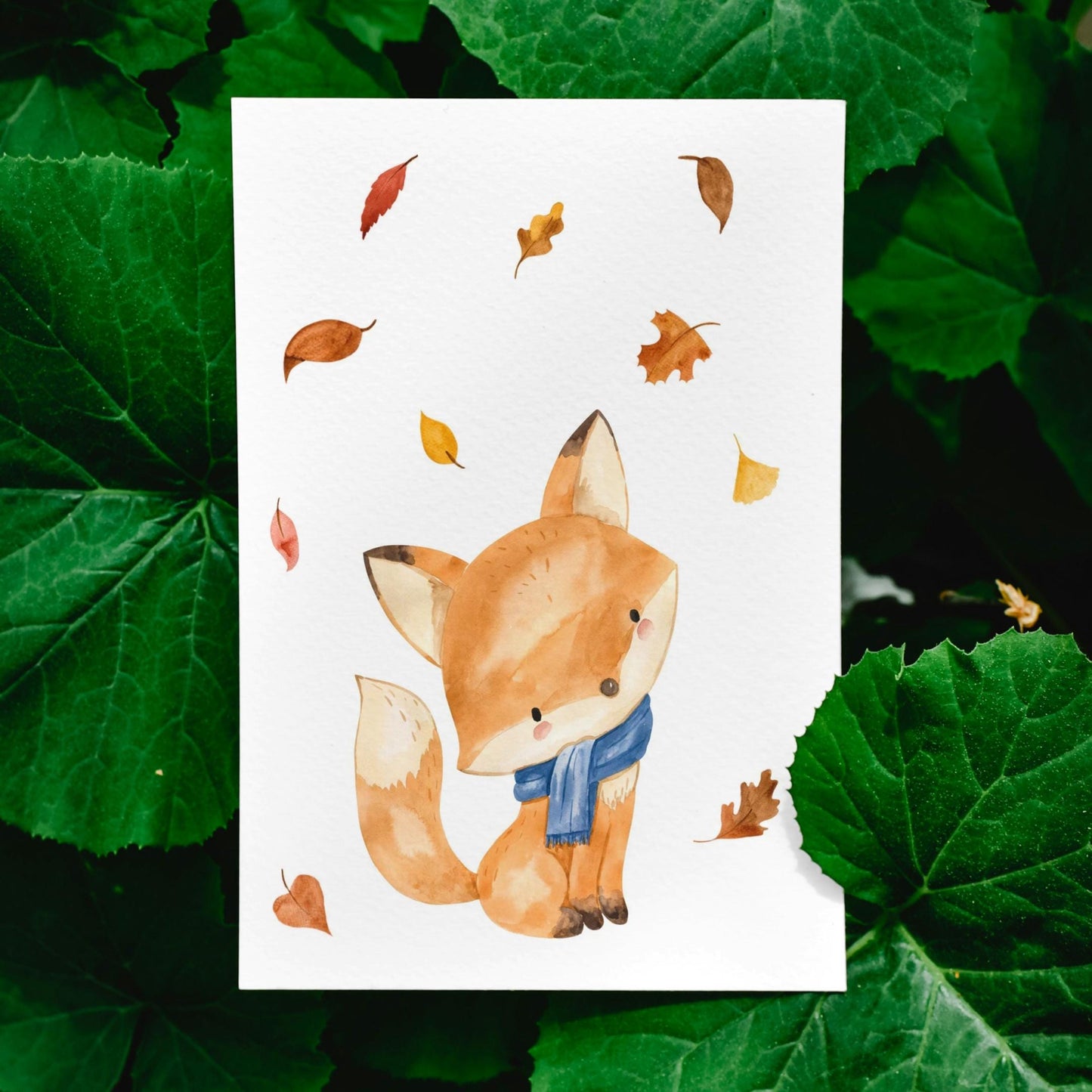 Karte Fuchs & Herbstlaub A6 zeigt einen Fuchs mit Schal und buntem Herbstlaub, gedruckt auf hochwertigem, mattem Naturpapier. Perfekt für Grüße oder Dekoration.