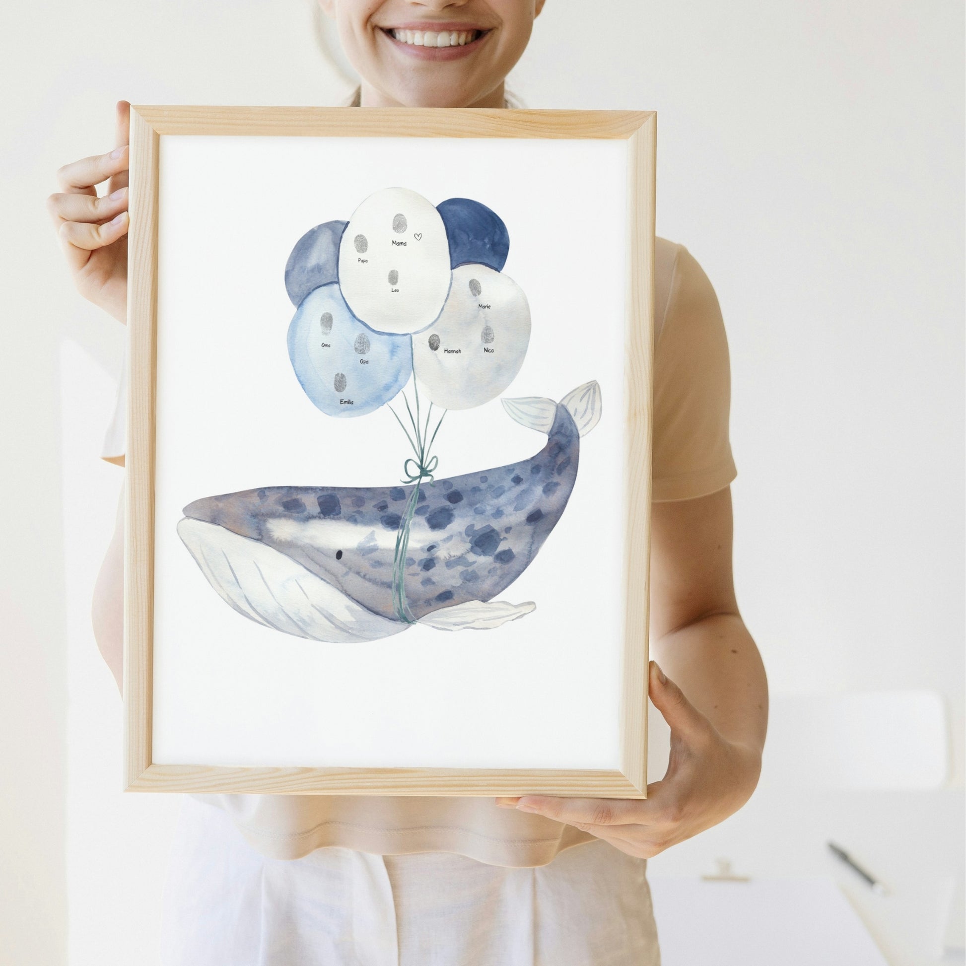 Person hält Poster Wal mit Ballons A4 & A3: Ein handgemaltes Poster, Wal, der mit blauen Ballons schwebt, ideal für Kinderzimmerdekoration und Gästebild für die Babyparty mit Fingerabdrücken.