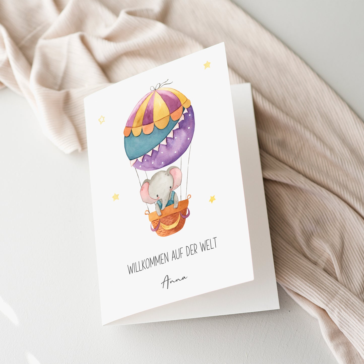 Personalisierte Geburtskarte Elefant & Heißluftballon A6 mit Aquarell-Elefant im Heißluftballon und Willkommen auf der Welt Text, inklusive Namen.