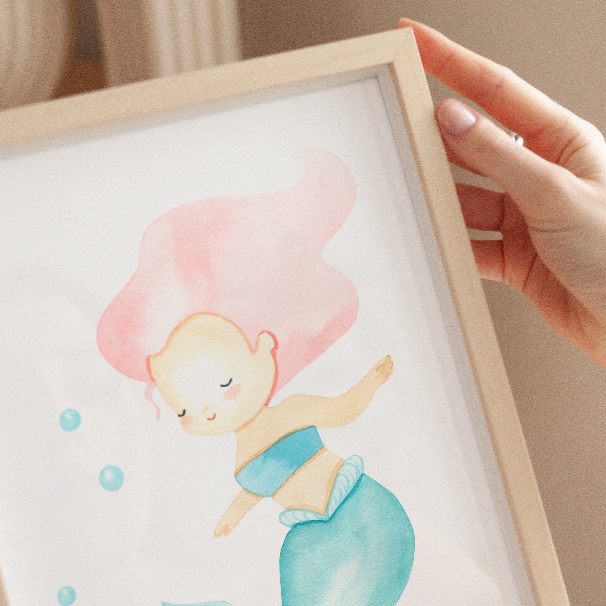 Poster Meerjungfrau rosa A3 & A4 zeigt eine Hand, die ein Bild einer Meerjungfrau hält, ideal für Kinderzimmerdekoration auf hochwertigem, mattem Naturpapier.