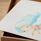 Poster Meerjungfrau türkis A3 & A4: Zeichnung einer Meerjungfrau auf einem Holzbox-ähnlichen Hintergrund, ideal als Kinderzimmerdeko oder Geschenk, gedruckt auf hochwertigem, mattem Naturpapier.