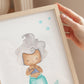Poster Meerjungfrau silber A3 & A4: Eine Hand hält ein illustriertes Bild einer Meerjungfrau, ideal als Kinderzimmerdeko oder Geschenk, gedruckt auf festem Naturpapier.