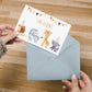 Einladung Kindergeburtstag Tiere A6: Hand hält Einladungskarte mit Partybunting und Cartoon-Safari-Tieren in Partyhüten aus grauem Umschlag, ideal für Kindergeburtstage.