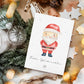 Personalisierte Weihnachtskarte Weihnachtsmann A6 mit Santa-Motiv und Frohe Weihnachten Text, umgeben von Weihnachtsdekorationen wie Tannenzweigen, Holzsternen und Glaskugeln.