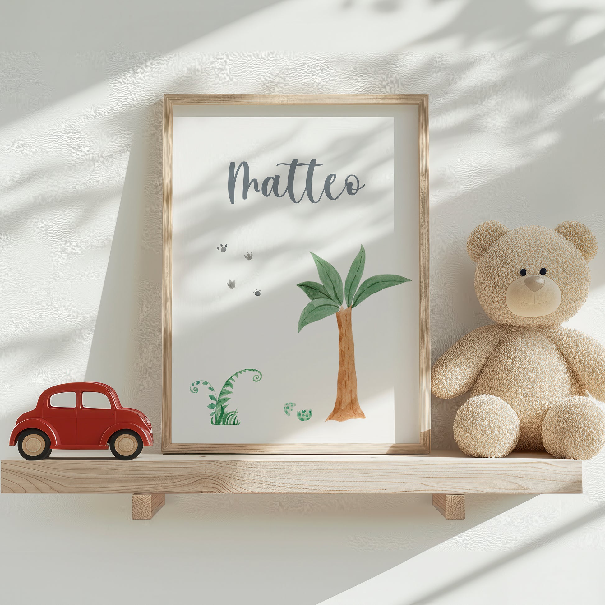 Namensposter personalisiert 3er Set: Dinosaurier A4 & A3, dargestellt in einem Holzrahmen mit Matteo-Schriftzug und minimalistischen Dino-Illustrationen, neben Spielzeugauto und Plüschteddy.