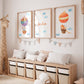 Personalisierte Namensposter im 3er Set: Elefant und Fuchs im Heißluftballon, mittig mit Namen Emilia, unterstrichen durch pastellfarbene Deko im Kinderzimmer.