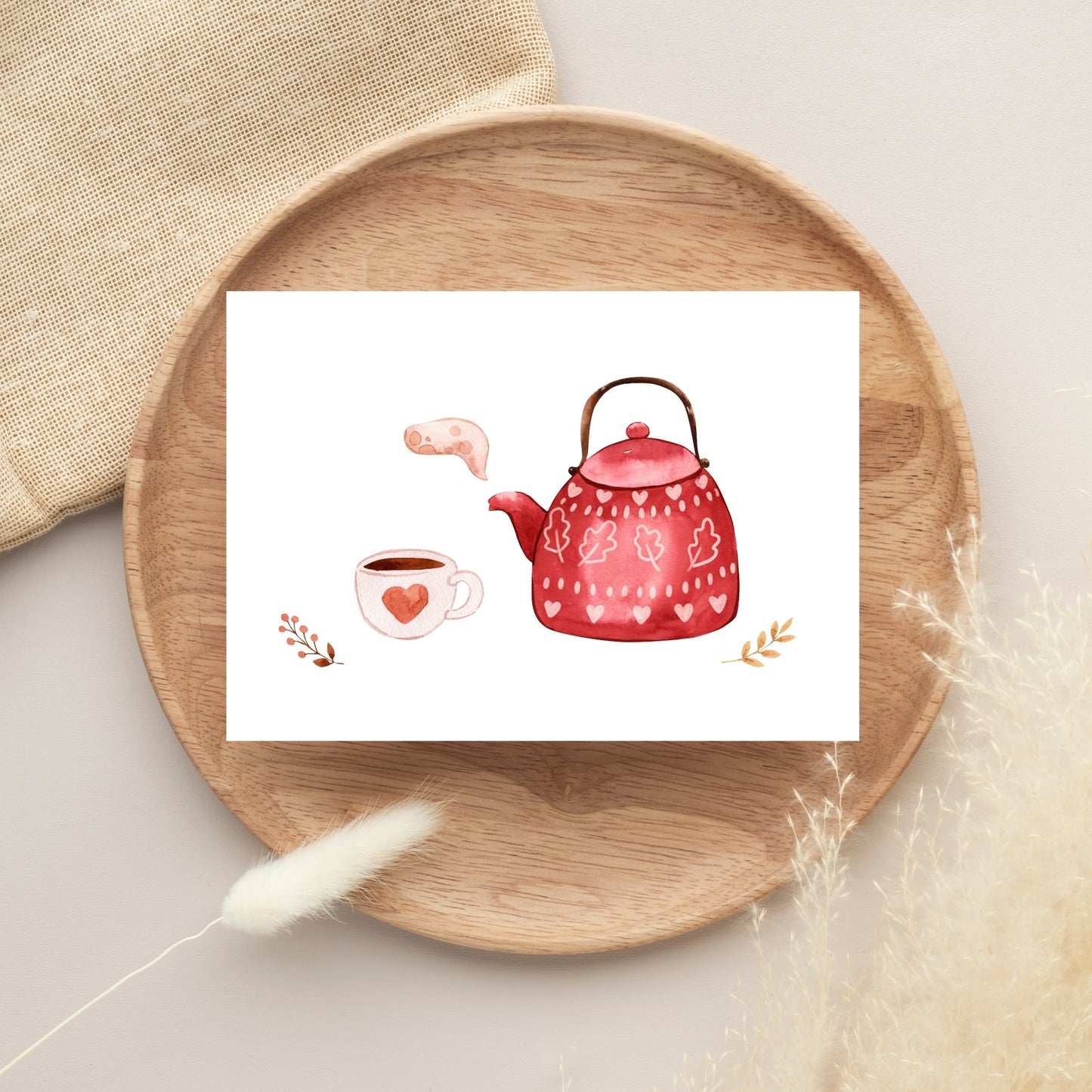 Postkarte Karte Tea Time A6 auf Holztablett, zeigt Aquarell einer roten Teekanne mit Herzen, Teetasse und Zweigen. Ideal für Einladungen oder Grüße.