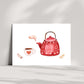 Karte Tea Time A6 zeigt eine rot illustrierte Teekanne mit Herzen und Blättern, dampfend in eine weiße Tasse. Zwei kleine Zweige flankieren die Szene.