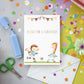 Geburtstagskarte Karte Kindergeburtstag Fußball A6 mit handgemalten Fußball-Motiven, Herzlichen Glückwunsch-Schriftzug, umgeben von Bastelmaterialien wie Schere und Papier.