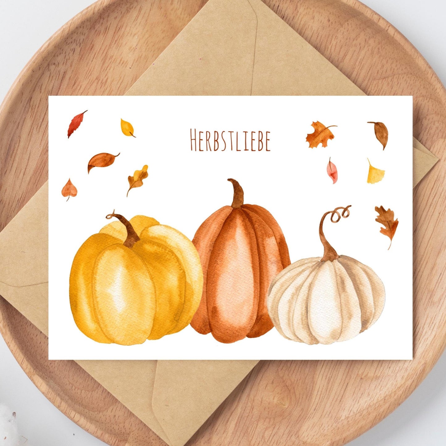 Postkarte Herbstliebe Kürbis & Herbstlaub A6, Kürbisse und Herbstblätter auf einem Holztablett, gedruckt auf mattem, unbeschichtetem 300g Naturpapier.