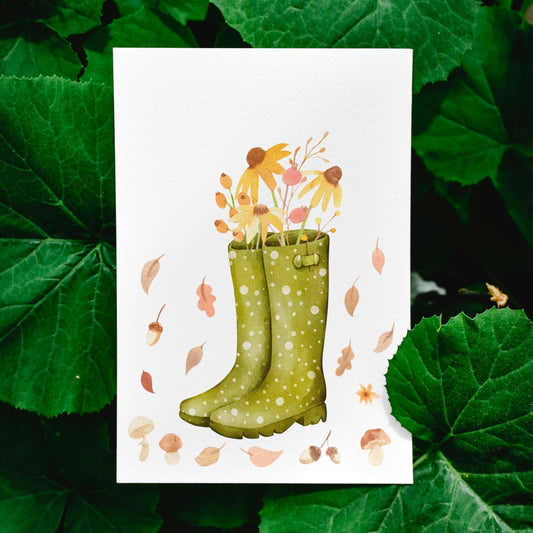 Karte Herbstblumen A6: Eine Postkarte mit herbstlichem Gartenmotiv zeigt grüne Stiefel, gefüllt mit bunten Blumen. Gedruckt auf hochwertigem, mattem Naturpapier.