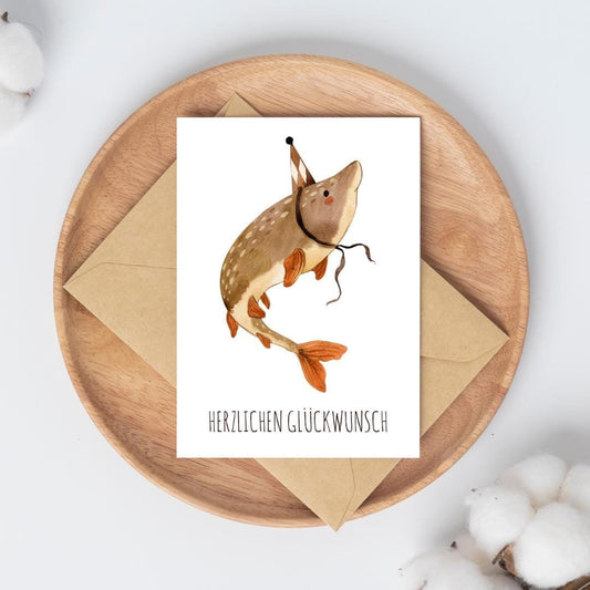Karte Fisch Herzlichen Glückwunsch A6 zeigt einen Fisch mit Partyhut, handgemalt auf hochwertigem Naturpapier, perfekt für Kindergeburtstage und Tierliebhaber.