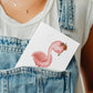Person hält Karte Flamingo Vintage A6 mit Flamingo-Bild; handgefertigt auf 300g Naturpapier, ideal als Gruß- oder Glückwunschkarte.