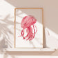 Poster Qualle pink A3 & A4 zeigt ein fröhliches, handgemaltes Bild einer lächelnden Qualle im Holzrahmen, ideal für das Kinderzimmer.