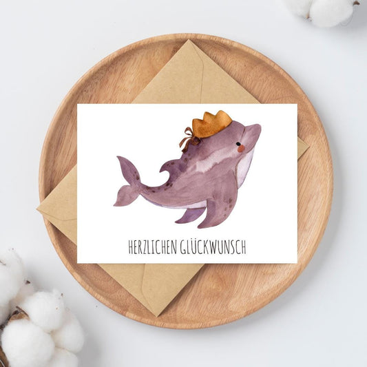 Karte Delfin Herzlichen Glückwunsch A6 zeigt einen niedlichen Delfin mit Krone, perfekt als handgefertigte Glückwunschkarte für Kindergeburtstage.