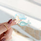 Finger mit einem handgemalten Sticker Meerjungfrau blau, gezeigt auf einem Fingernagel. Ideal für Bullet Journals oder Handyhüllen. Spritzfest und langlebig.