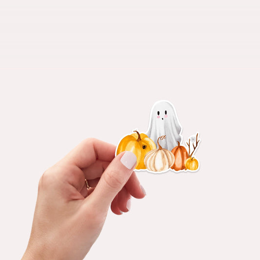 Hand hält Sticker Halloween mit einem handgemalten Geist und Kürbissen, ideal für Bullet Journals, Laptops oder Handyhüllen. Hochwertiges, spritzfestes Vinyl.