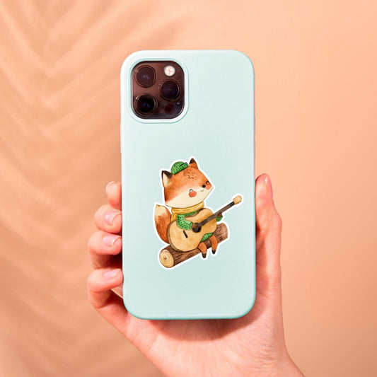 Person hält eine Handyhülle mit einem Cartoon-Fuchs, der Gitarre spielt. Produkt: Sticker Fuchs & Gitarre, verleiht Handyhüllen einen individuellen Look.