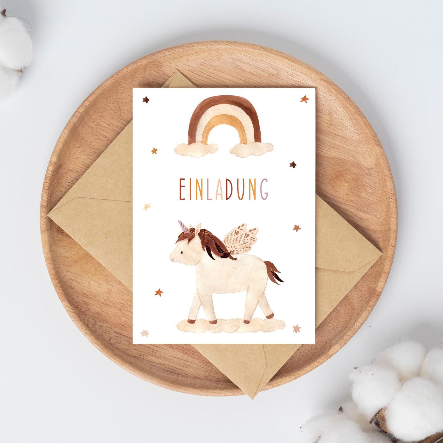 Einladung Kindergeburtstag Einhorn Boho A6: Karte mit Einhorn und Regenbogen im Boho-Stil auf einem Teller, gedruckt auf mattem Naturpapier.