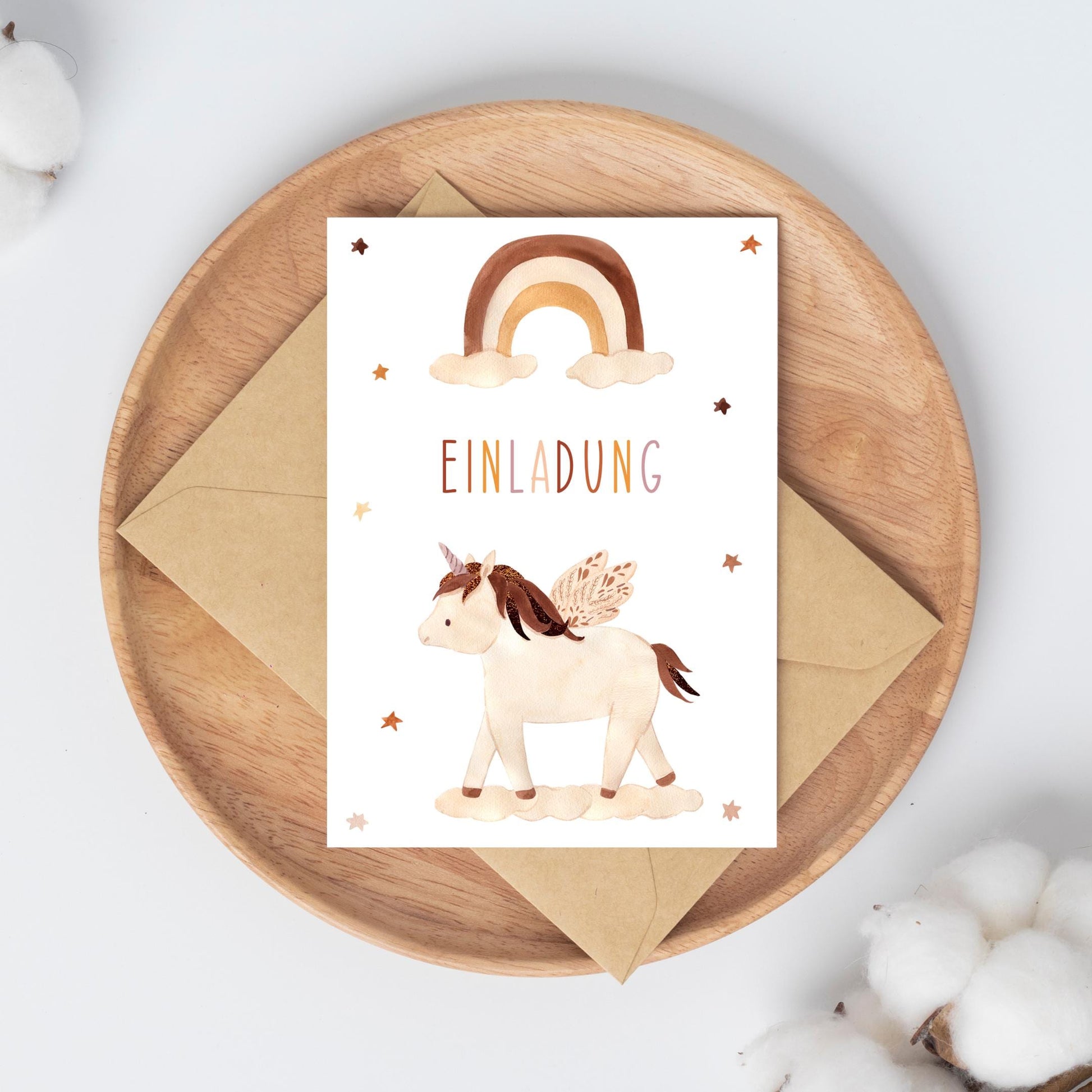 Einladung Kindergeburtstag Einhorn Boho A6: Karte mit Einhorn und Regenbogen im Boho-Stil auf einem Teller, gedruckt auf mattem Naturpapier.