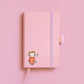 Sticker Katze auf einem rosa Notizbuch: Cartoon-Katze im Vintage-Stil, ideal für Bullet Journals oder Laptops. Hochwertiges, haltbares Vinyl, handgefertigt.