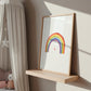 Poster Regenbogen A3, A4 & A5: Ein handgemaltes Bild mit Regenbogen und Herz, auf einem Holzregal in einem gemütlichen Kinderzimmer platziert, umgeben von minimalistischer Dekoration.