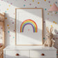 Poster Regenbogen A3, A4 & A5: Handgemaltes Regenbogenbild mit Herz auf einem weißen Regal, neben einem beigen Hasen, ideal für farbenfrohe Kinderzimmerdekoration.