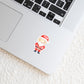 Sticker Weihnachtsmann auf einem silbernen Laptop, zeigt einen handgefertigten, langlebigen Vinyl-Aufkleber, ideal für personalisierte Weihnachtsdekorationen auf verschiedenen Oberflächen.