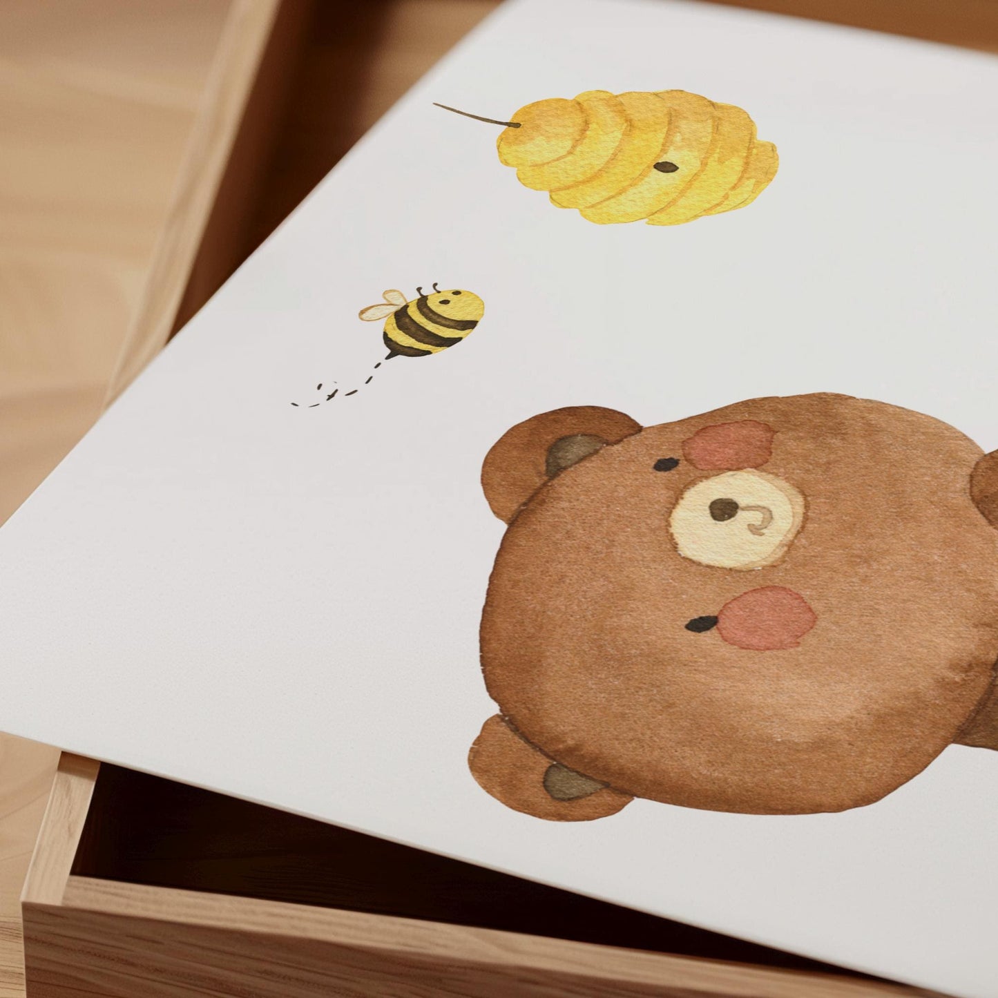Namensposter personalisiert im 3er Set: Bären und Bienen A3 & A4. Aquarellzeichnung eines Teddygesichts, fliegender Biene und hängendem Honigwabenmotiv auf weißem Papier in Holzbox.