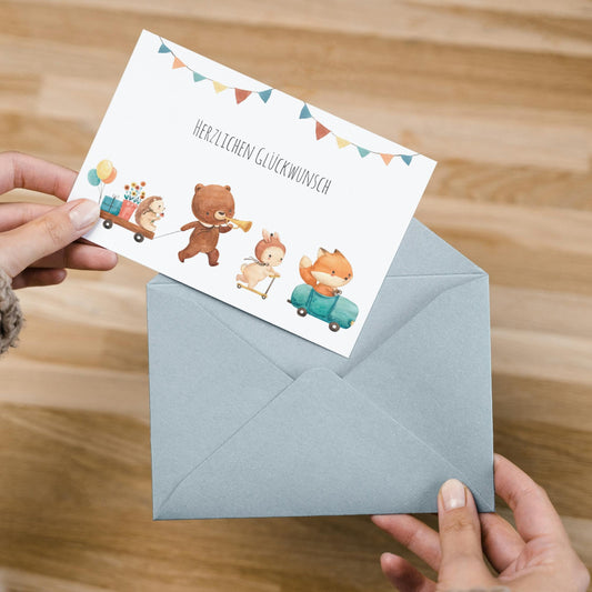 Hände halten die Karte Karte Kindergeburtstag Tierparade Waldtiere A6 mit Tiermotiven und Herzlichen Glückwunsch auf hochwertigem Naturpapier, ideal für Kindergeburtstage.