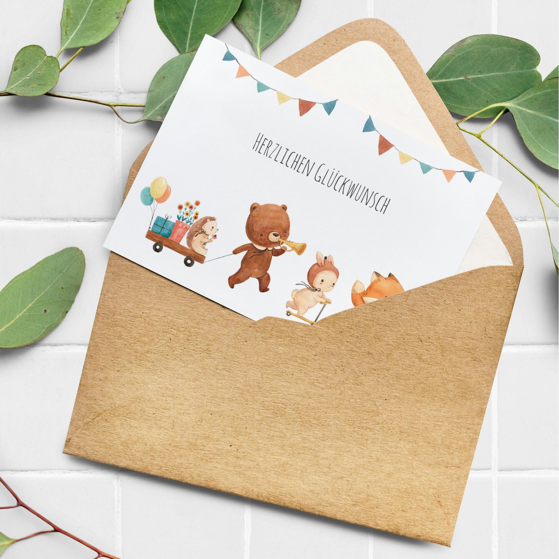 Karte Kindergeburtstag Tierparade Waldtiere A6: Aquarellkarte mit Herzlichen Glückwunsch und Tierparade aus Bär, Igel, Hase und Fuchs, teils sichtbar im Umschlag.