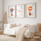 Namensposter personalisiert im 3er Set: Elefant und Fuchs im Heißluftballon, begleitet von Wolken und Sternen, über einem Kinderbett in neutralen Tönen.