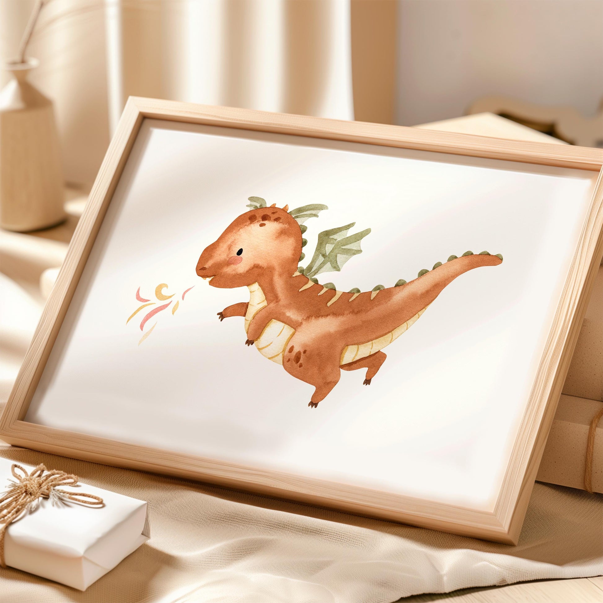 Poster Feuerdrache A3 & A4 in hellem Holzrahmen, zeigt kleinen Drachen mit grünlichen Flügeln und Flammen, auf neutralem Tuch neben Geschenkbox und Vase.