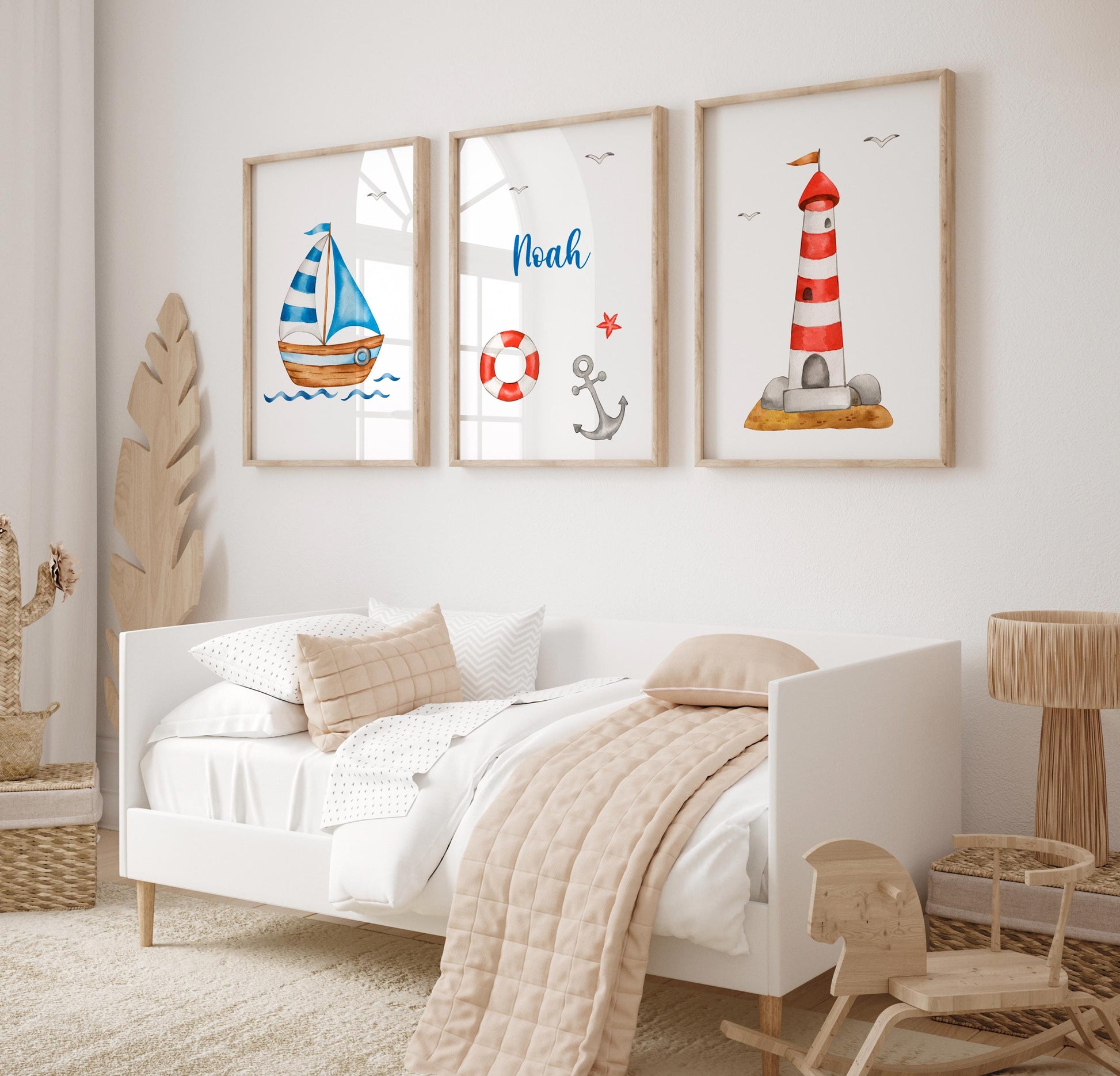 Namensposter personalisiert im 3er Set: Segelboot, Leuchtturm, und Name Noah mit maritimen Motiven, gerahmt über einem Kinderbett in einem minimalistischen Raum.