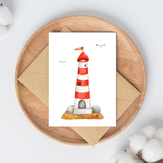 Postkarte Leuchtturm A6 mit Aquarell-Leuchtturm und Möwen, auf rundem Holzteller mit Umschlag und Baumwollzweigen arrangiert. Ideal für maritime Grüße oder Dekoration.