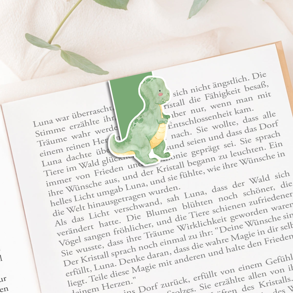Dino als Lesezeichen im geöffneten Buch